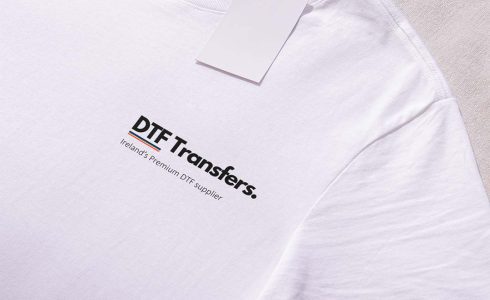 White shirt with 'DTF Transfers' logo prominently placed on the left breast, showcasing a clean and simple design.
